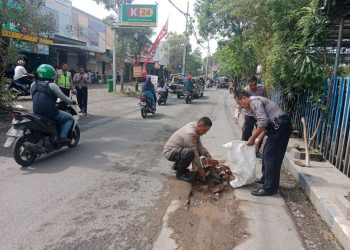 Personel Polsek Sedati Inisiatif Tambal Jalan Berlubang
