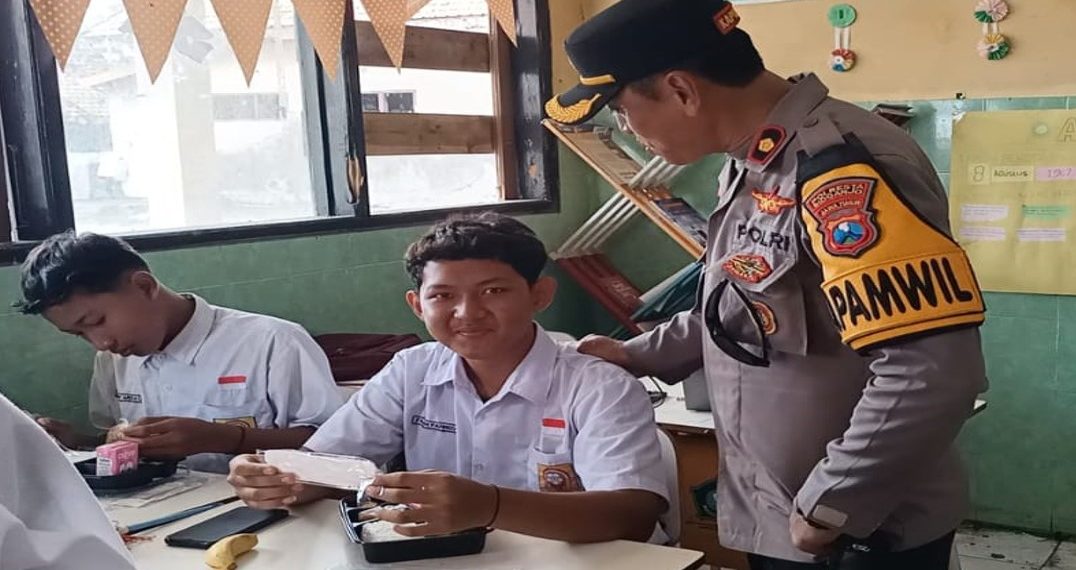 Naik Perahu, Kapolsek Buduran Bagikan Makan Siang Bergizi di Sekolah Wilayah Terpencil