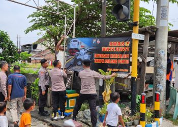 Polisi Pasang Spanduk Himbauan di Perlintasan Kereta Api Tidak Berpalang